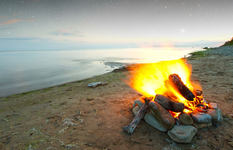 campfire on a deserted beach, a reference to micro-adventures and hiking