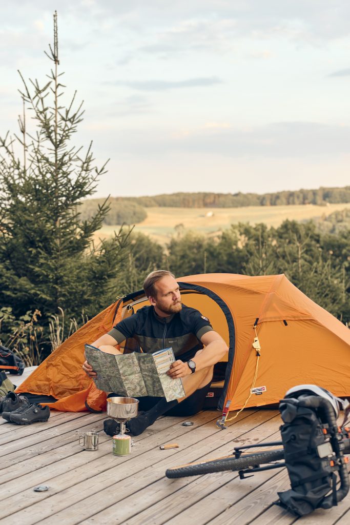 man leest kaart voor de tent