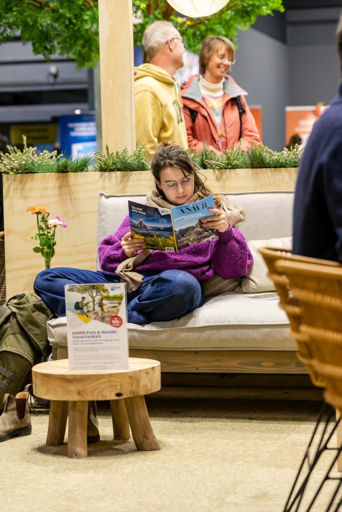 Recap Fiets en Wandelbeurs Nederland 2025: boekje lezen in de ANWB-stand.