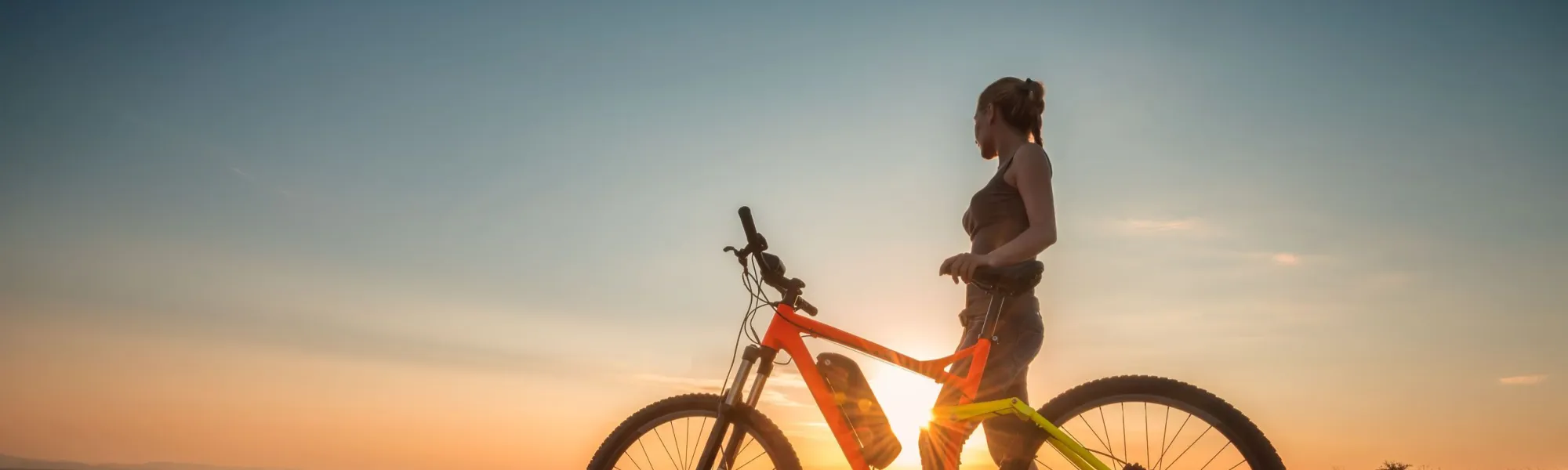E-bikester bewondert de zonsondergang als headerbeeld voor het onderwerp 'aanvullende promotie E-bike Challenge'